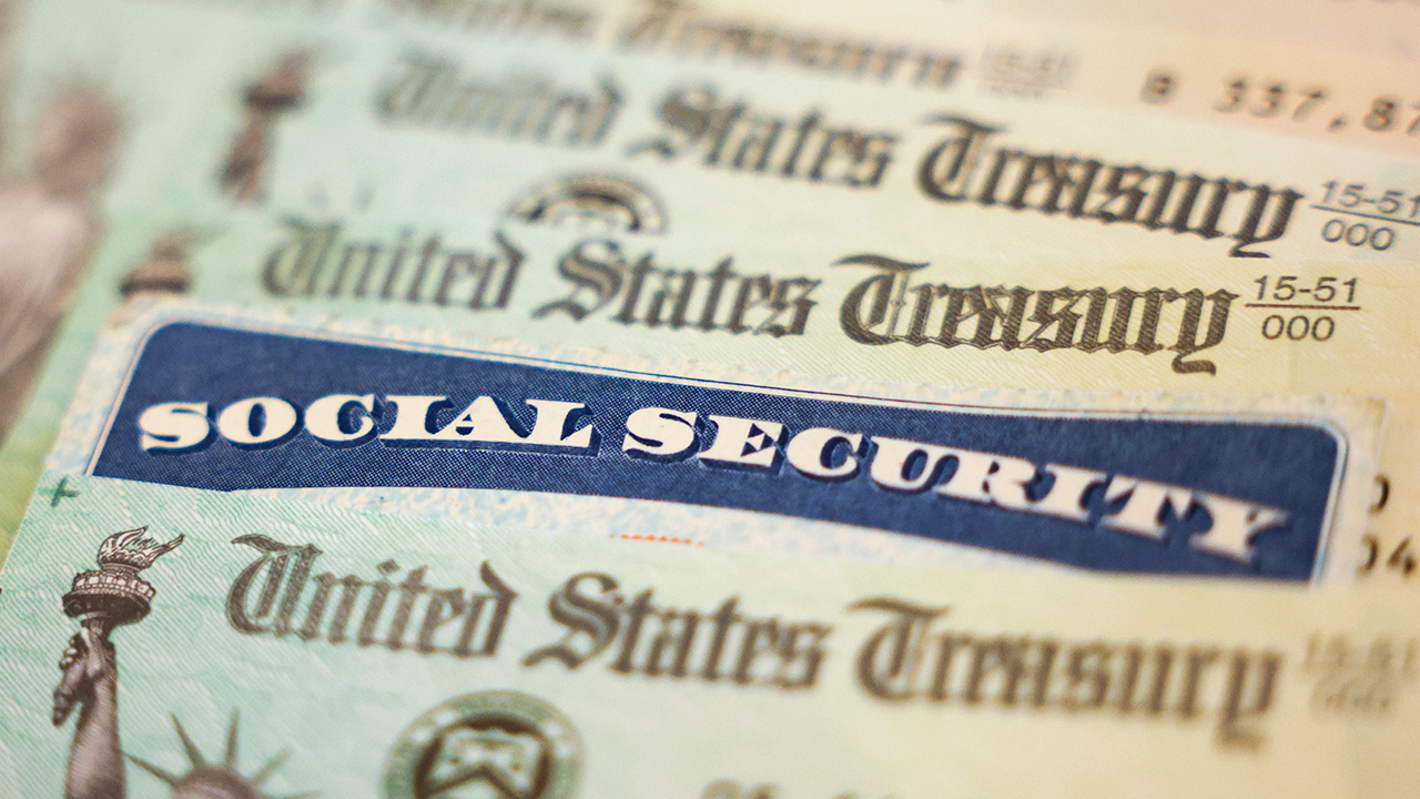 Social Security card and U.S. Treasury checks on a table, symbolizing financial security and government benefits.